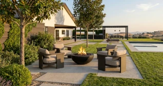 An outdoor living space with a pool, lawn, and lounge seating
